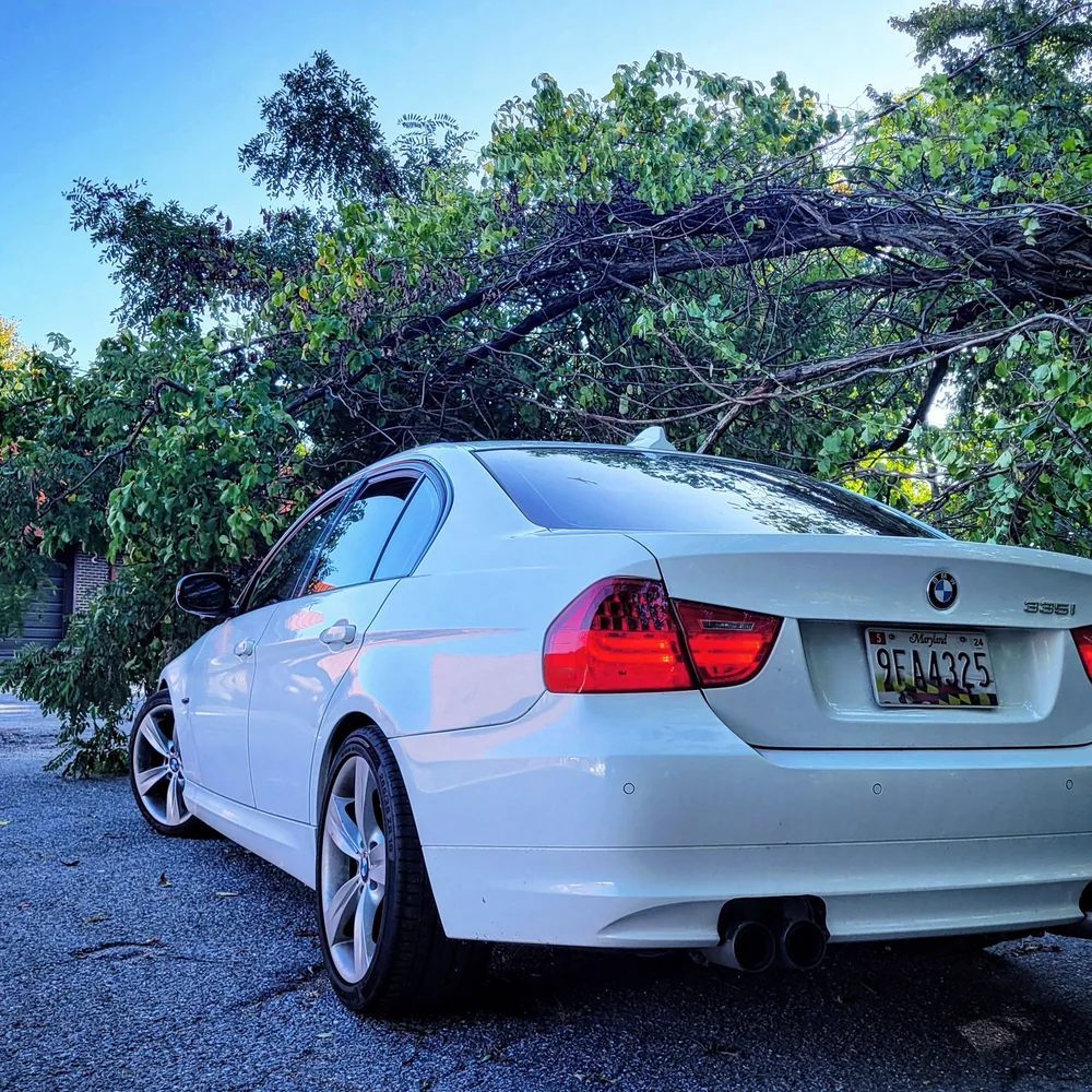 White BMW photographed from the rear three-quarter angle outdoors